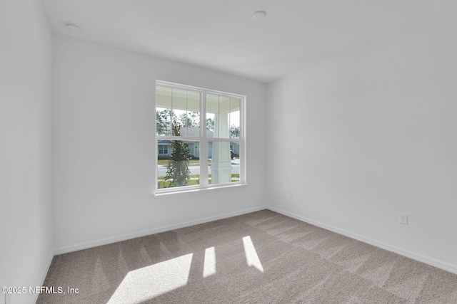 carpeted spare room with baseboards