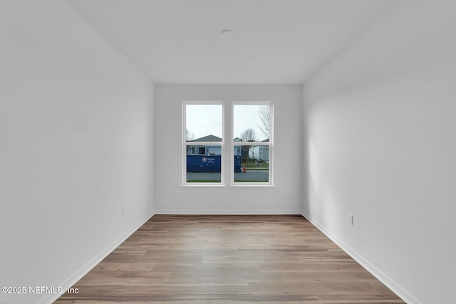 unfurnished room with light wood finished floors and baseboards