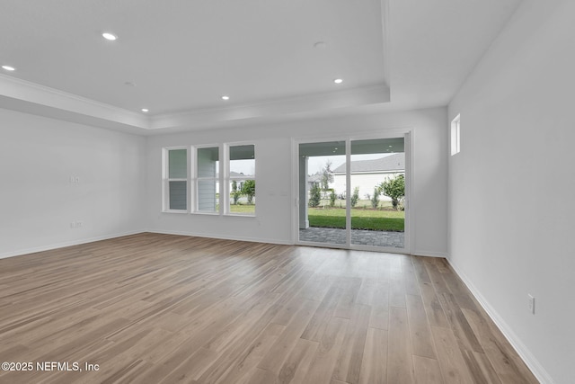 unfurnished living room featuring a tray ceiling, light wood-style flooring, and recessed lighting