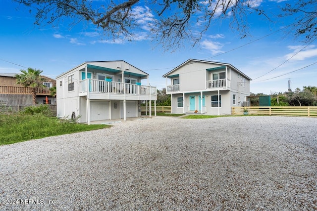 rear view of house with a garage and a balcony