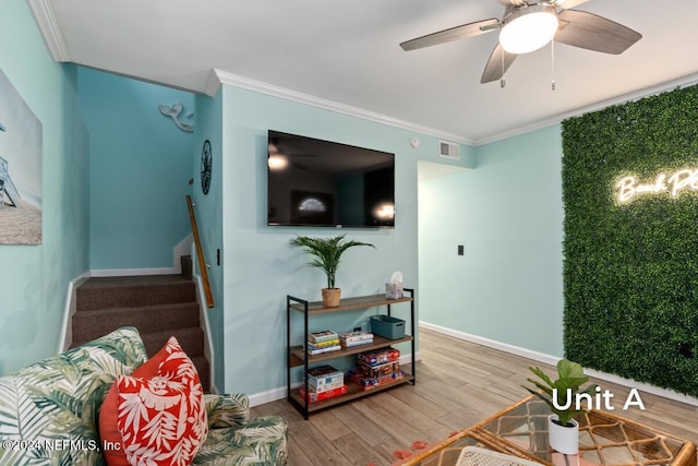 living room featuring hardwood / wood-style flooring, ornamental molding, and ceiling fan