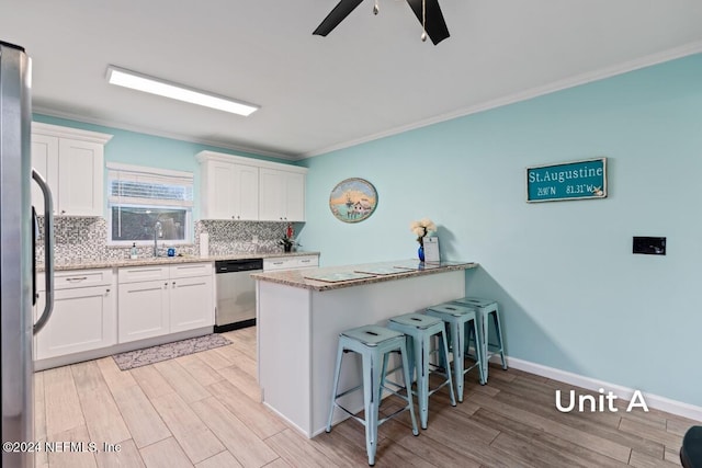 kitchen with white cabinetry, appliances with stainless steel finishes, sink, and kitchen peninsula