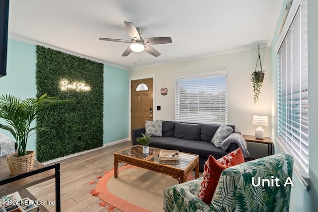 living room featuring hardwood / wood-style flooring, ornamental molding, and ceiling fan