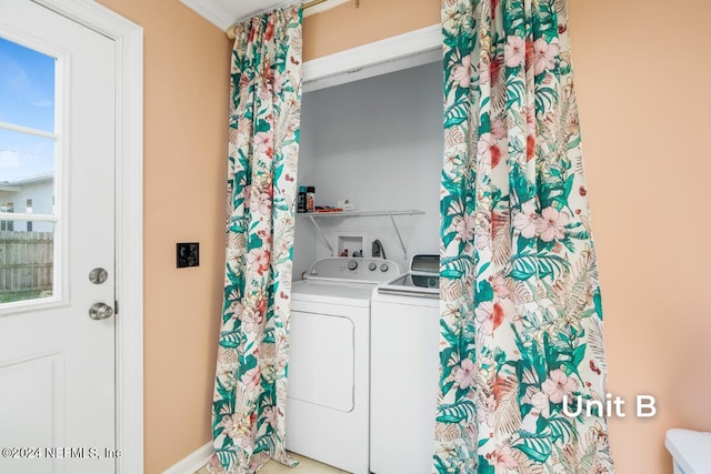 clothes washing area featuring ornamental molding and separate washer and dryer