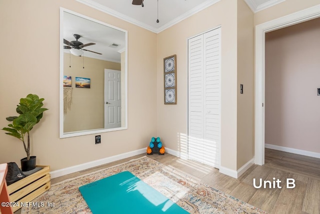 exercise room featuring ornamental molding, wood-type flooring, and ceiling fan