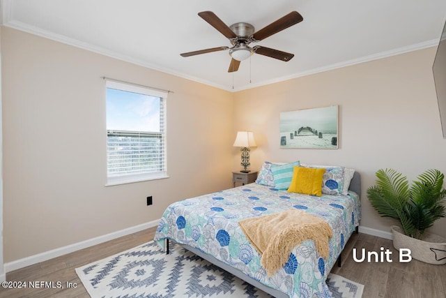 bedroom with hardwood / wood-style floors, ornamental molding, and ceiling fan