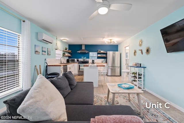 living room featuring ceiling fan, a wall mounted AC, sink, and light tile patterned floors