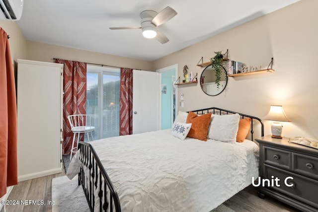 bedroom with wood-type flooring, an AC wall unit, and ceiling fan