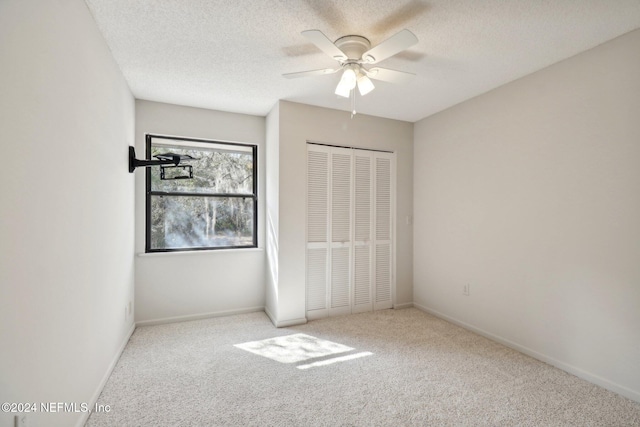 unfurnished bedroom with light colored carpet, ceiling fan, and a closet