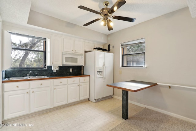 kitchen featuring white cabinetry, white appliances, sink, and a healthy amount of sunlight