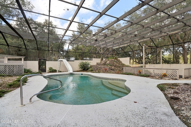 view of swimming pool with glass enclosure, a patio, and a water slide