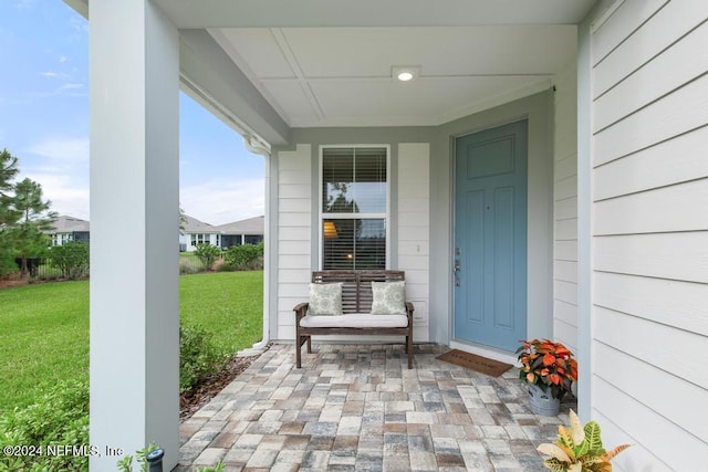 view of exterior entry with a lawn