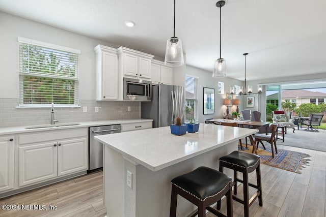 kitchen featuring stainless steel appliances, white cabinets, and a healthy amount of sunlight