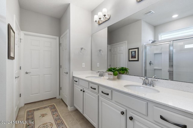 bathroom featuring vanity, tile patterned floors, and a shower with shower door