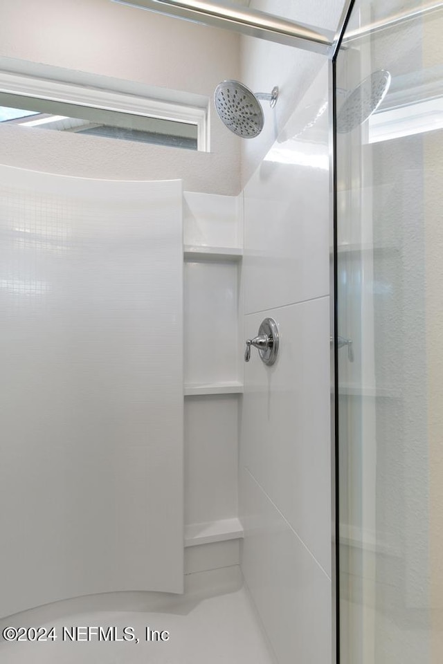 bathroom featuring a shower with shower door