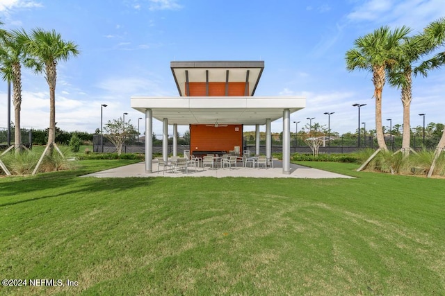 exterior space with ceiling fan, a lawn, and a patio