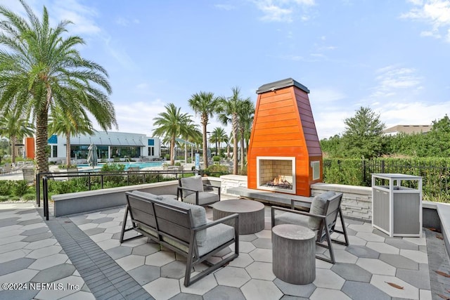 view of patio / terrace with a swimming pool and an outdoor living space with a fireplace