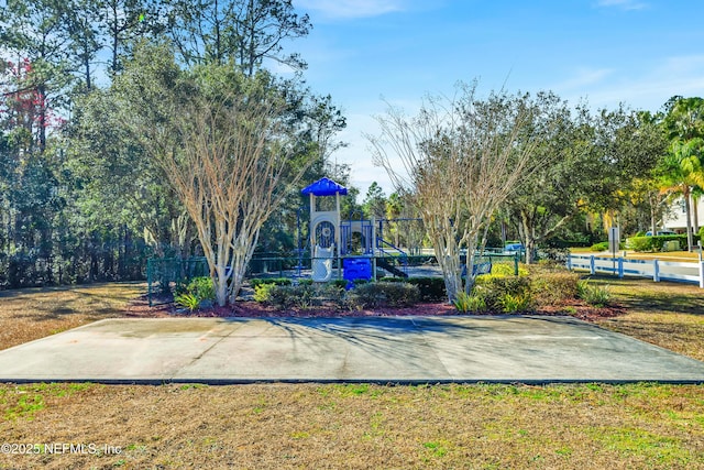 exterior space featuring a lawn and basketball hoop