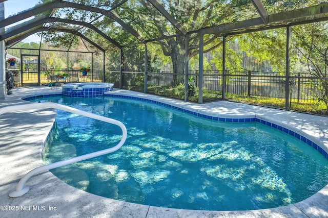 view of pool with an in ground hot tub, glass enclosure, and a patio area