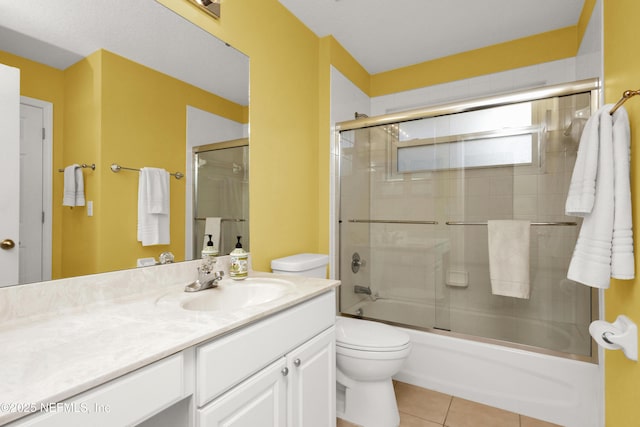 full bathroom with enclosed tub / shower combo, vanity, toilet, and tile patterned flooring