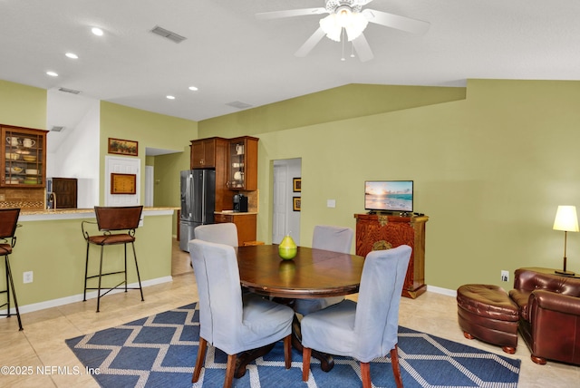 dining room with vaulted ceiling, light tile patterned flooring, and ceiling fan