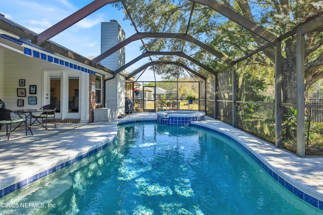 view of pool with an in ground hot tub, glass enclosure, and a patio