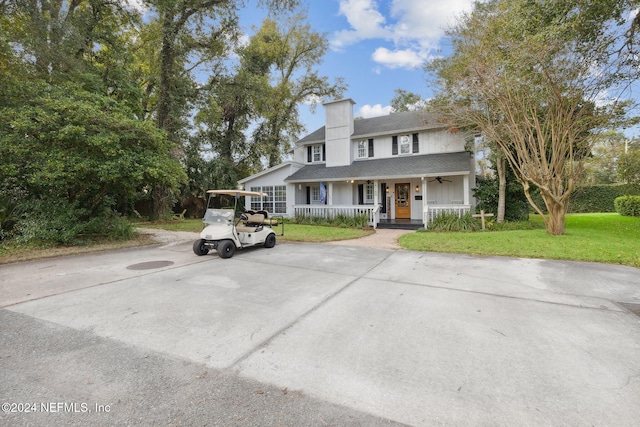 view of front of home featuring covered porch, a front yard, and a carport