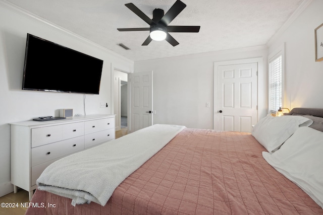 bedroom with a textured ceiling, ceiling fan, and crown molding