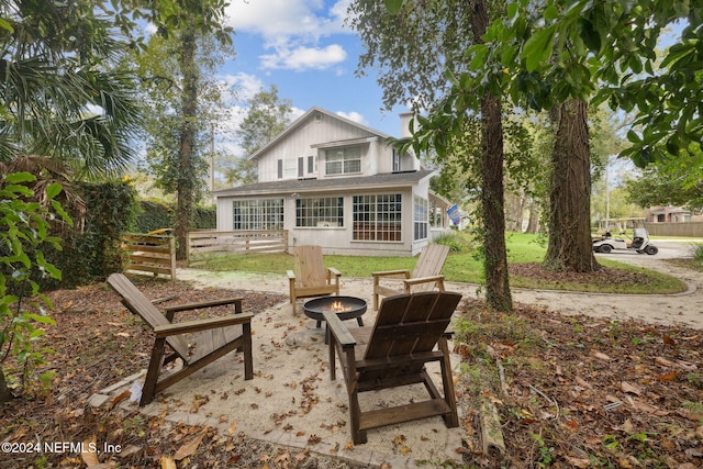 back of property with an outdoor fire pit