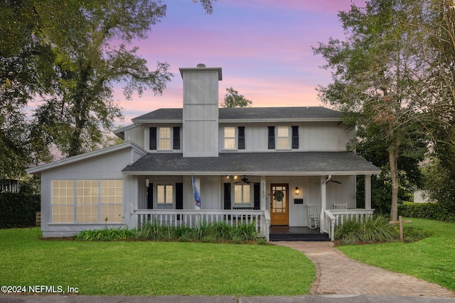 view of front of house featuring covered porch, a yard, and ceiling fan