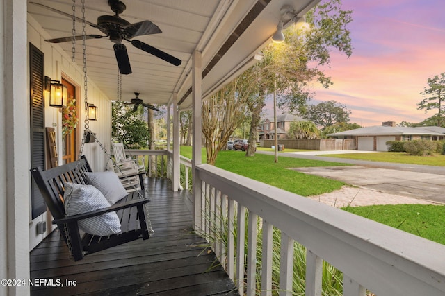 deck at dusk with a porch and a yard