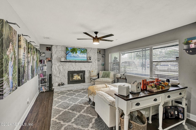 living room with a fireplace, dark hardwood / wood-style flooring, and ceiling fan