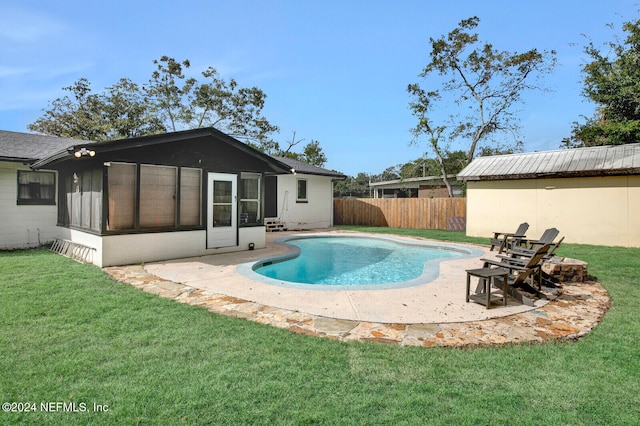 view of pool with a sunroom, a yard, and a patio area