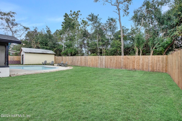 view of yard with a fenced in pool and an outdoor structure