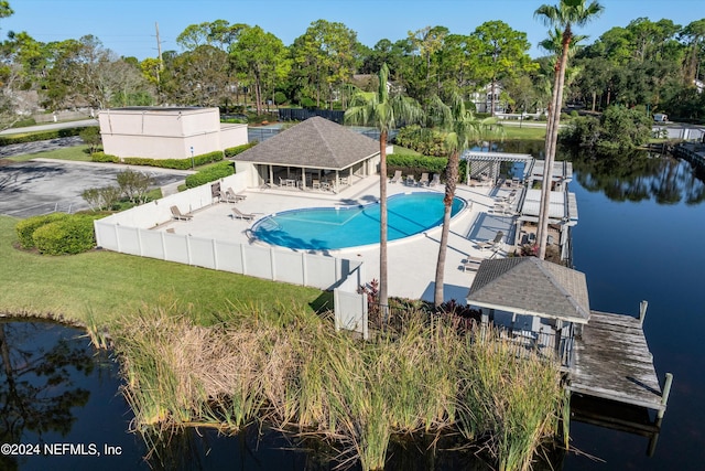 view of pool with a patio area, a water view, and a yard