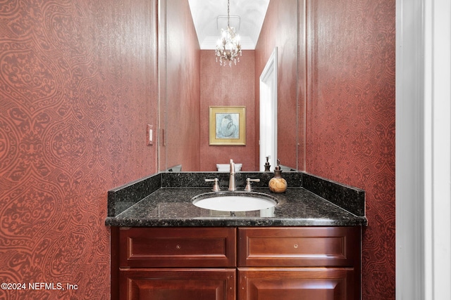 bathroom with vanity, crown molding, and a chandelier