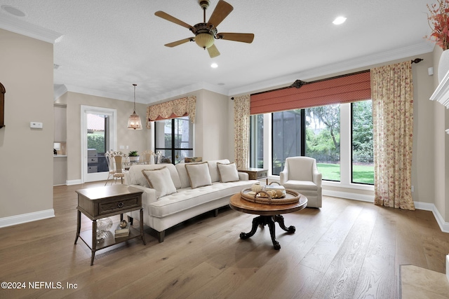 living room with hardwood / wood-style flooring, plenty of natural light, and ornamental molding