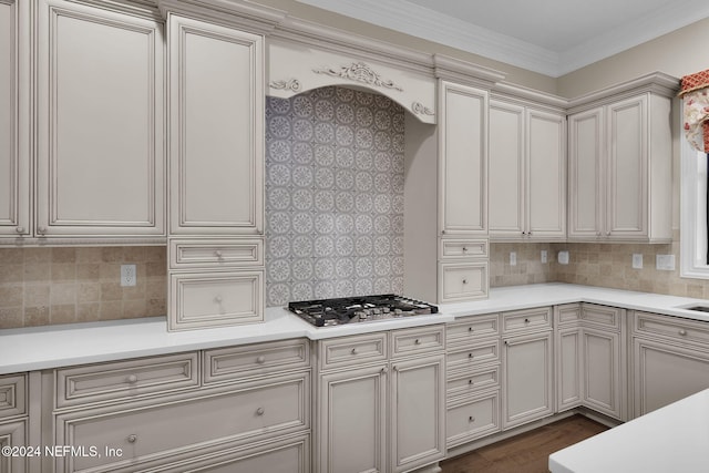 kitchen featuring dark hardwood / wood-style flooring, stainless steel gas cooktop, ornamental molding, and backsplash