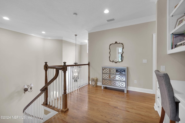 interior space featuring a chandelier, light hardwood / wood-style floors, and ornamental molding