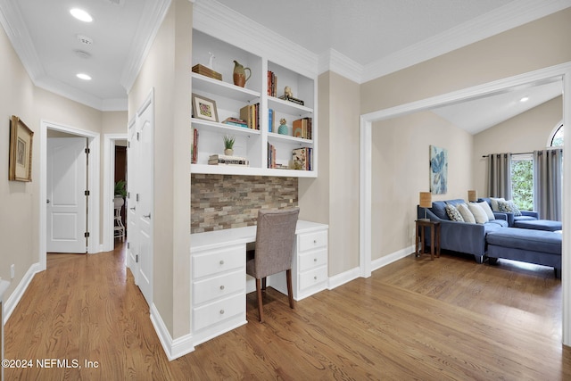 office space featuring light hardwood / wood-style floors, built in desk, and ornamental molding