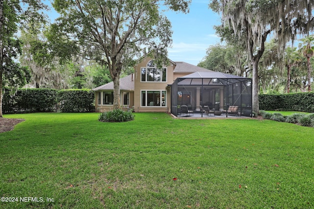 rear view of house featuring a lawn, glass enclosure, and a patio area