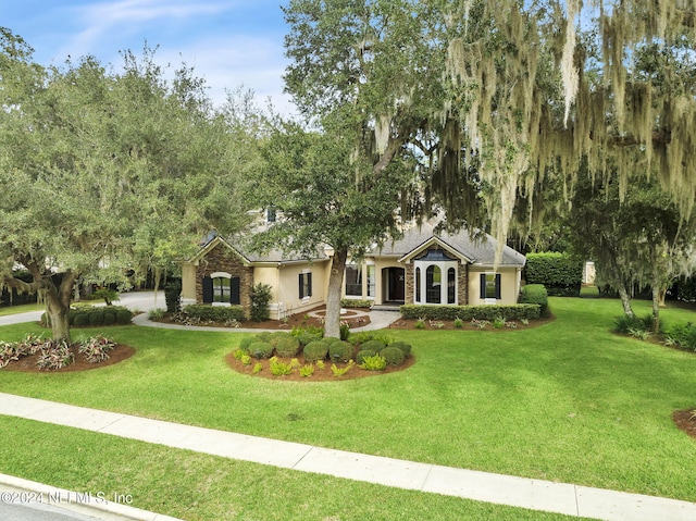 single story home featuring a front lawn