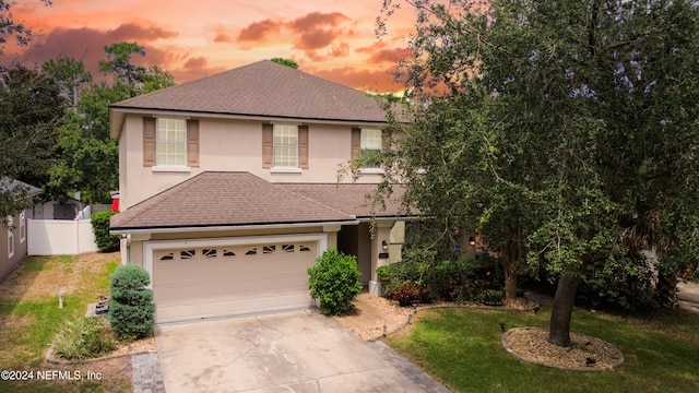 view of front of home with a garage and a lawn