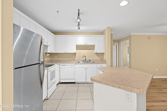 kitchen with sink, ornamental molding, white appliances, white cabinets, and light wood-type flooring