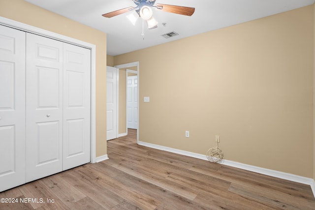 unfurnished bedroom featuring light hardwood / wood-style floors, ceiling fan, and a closet