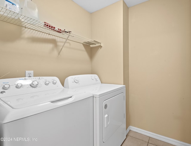 washroom with washer and clothes dryer and light tile patterned flooring