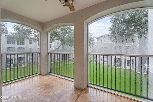 unfurnished sunroom featuring ceiling fan