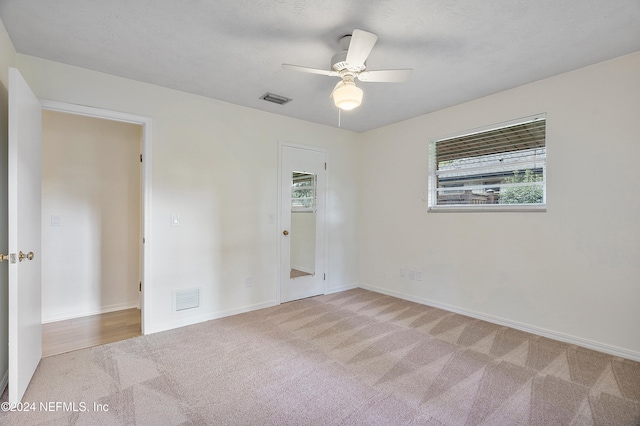 unfurnished room with ceiling fan and light colored carpet