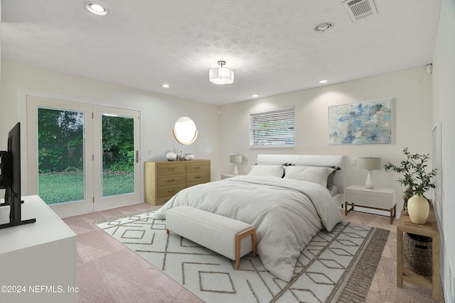 carpeted bedroom featuring access to outside and a textured ceiling