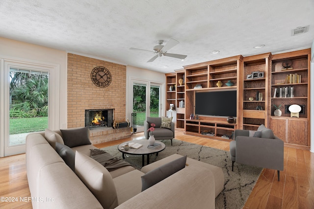 living room featuring light hardwood / wood-style floors, a textured ceiling, and a healthy amount of sunlight